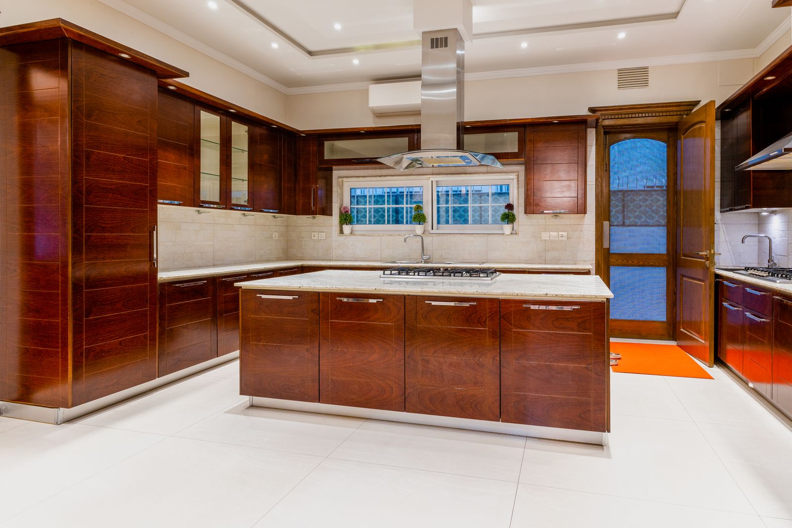 Cozinha contemporânea com marcenaria escura e bancada em mármore